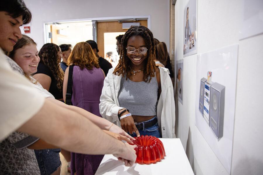 Students interact with art at an exhibition.