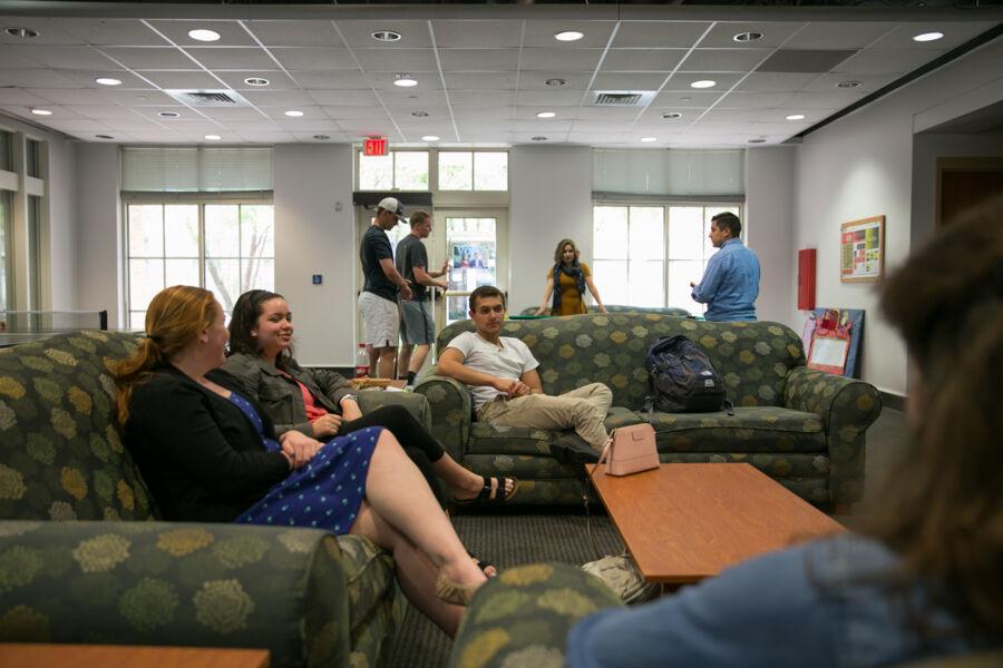 Students sitting on green couches around a coffee table