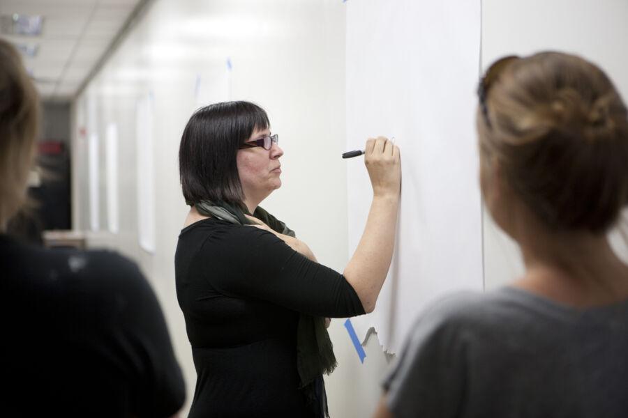 Hollis Hammonds writing on a white board in a classroom 