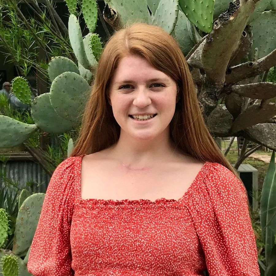 Isabel Plant wears a red blouse. Cacti are in the background.