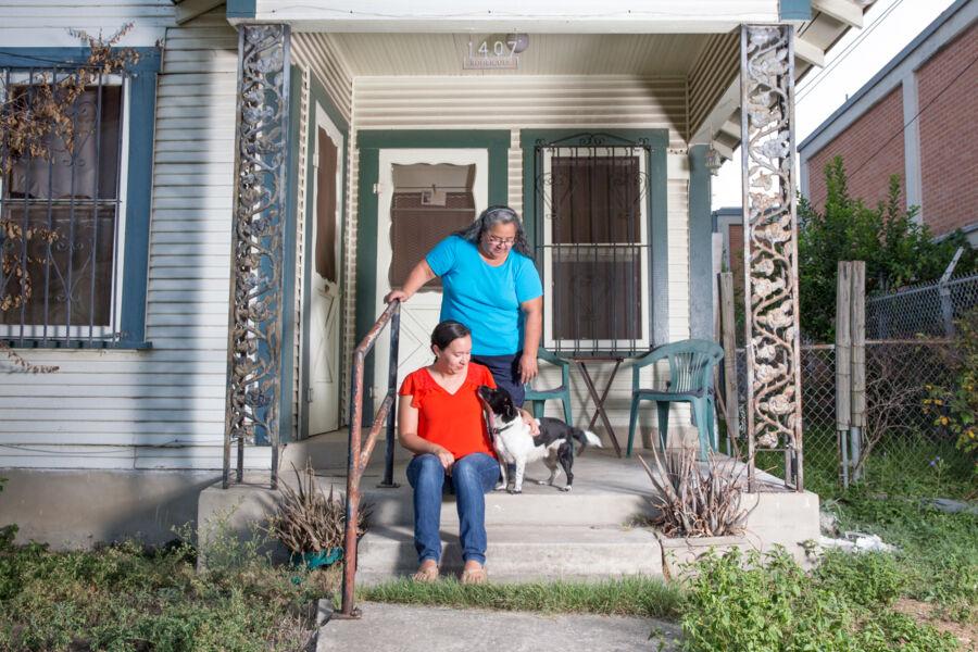 Victoria Rodriguez and her mother on their porch with their dog.