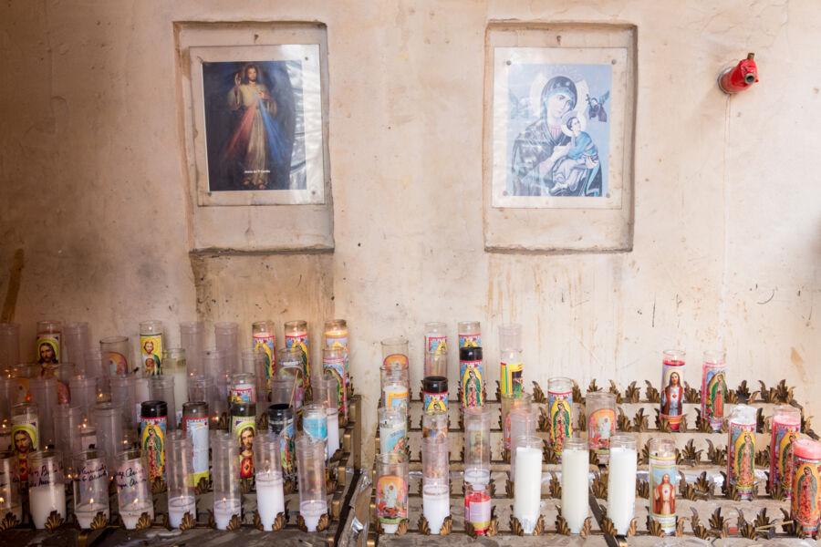 Candles and portraits at an altar at a church.