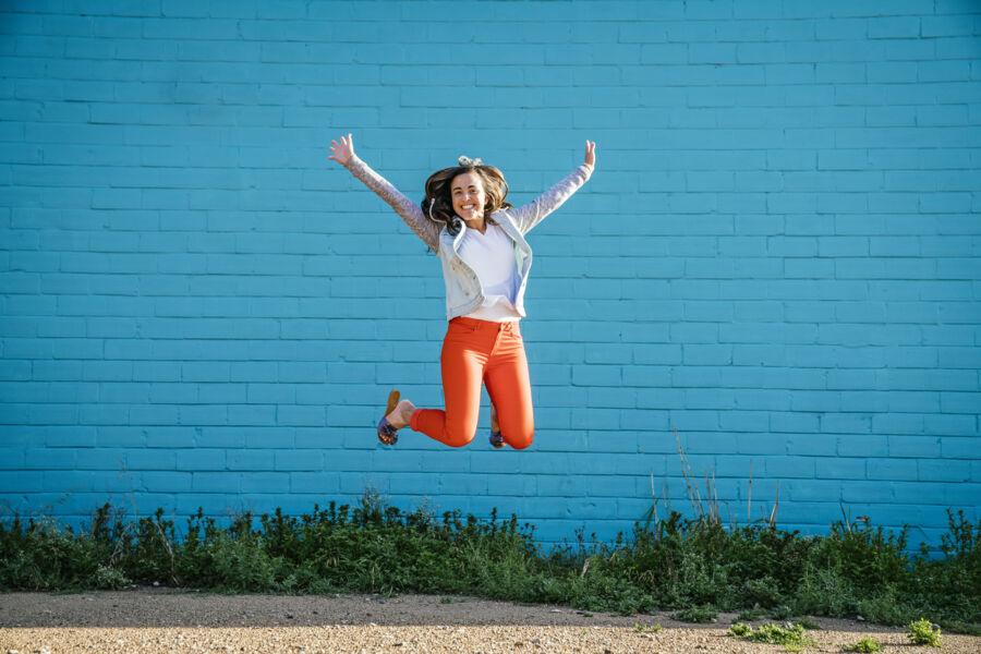 student jumping infront of colorful wall