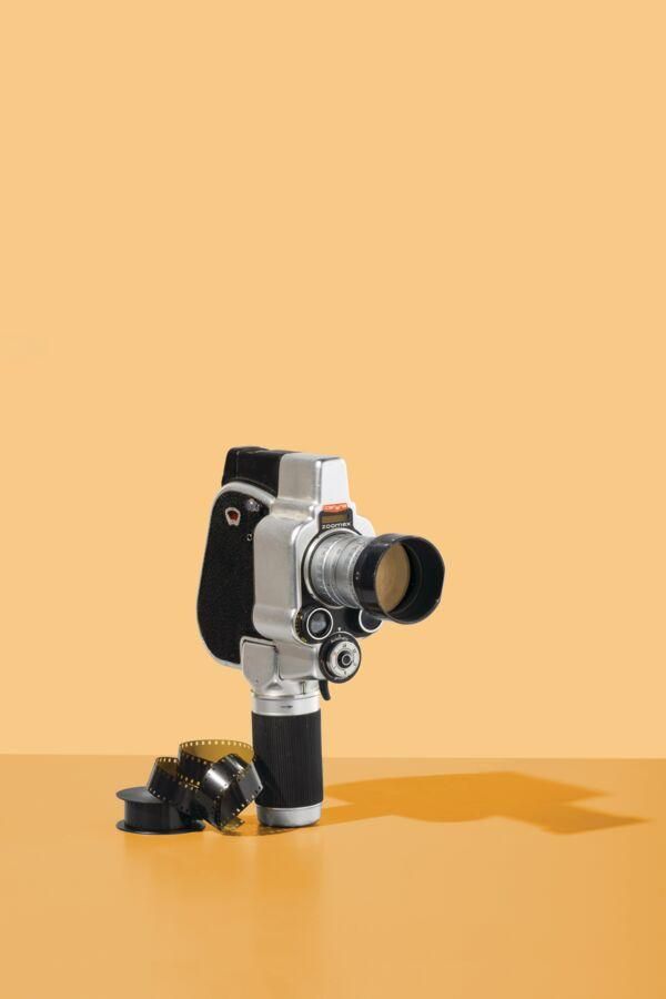 A vintage video camera on an orange background.