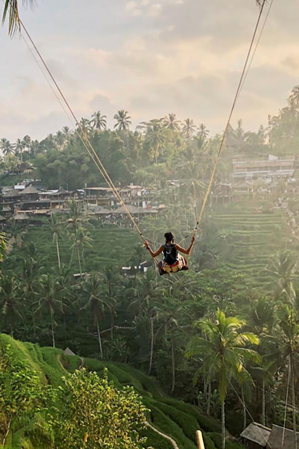 Aida Domingo swings across a field of greenery on a study abroad trip.