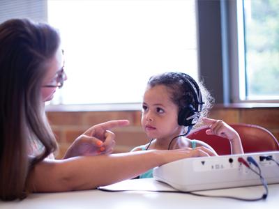 young girl with hearing headphones on 