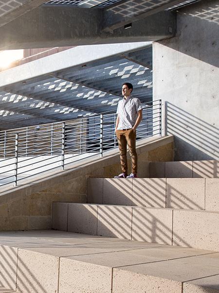 Miguel standing on a staircase, staring into the distance.