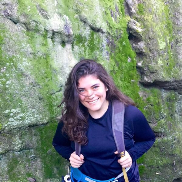 Sophie Gairo on a hike in front of a mossy wall