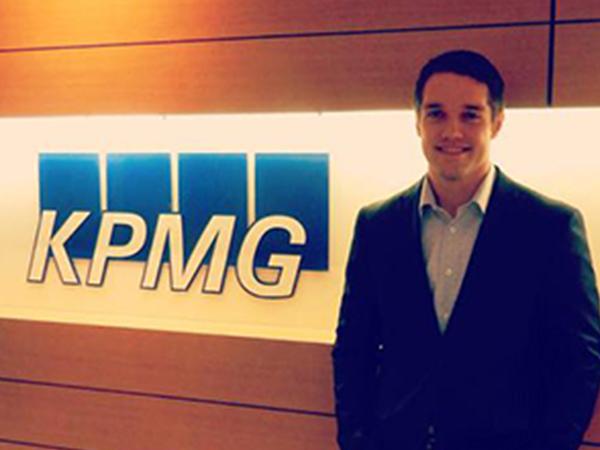 zach riola in front of a KPMG sign