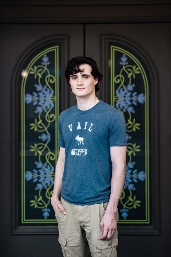 Sam McFarland poses in front of a decorated glass door
